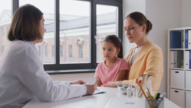 medicine, healthcare and pediatry concept - mother with little daughter and doctor with stethoscope at clinic