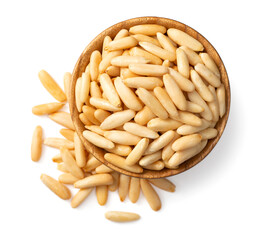 Roasted pine nuts in the wooden bowl. isolated on white background, top view.