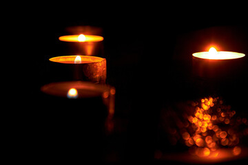 Candles in the dark with soft selective focus and bokeh.Burning candles on the table on the day of mourning