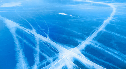 Steep slopes rises above a frozen lake with reflection on the ice at sunset -  Baikal lake