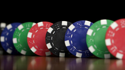 Poker chips stand in a row on a black background, a Domino effect. Playing poker chips are on the table, a symbol of casino