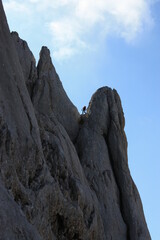 Mountain climber scaling a steep climbing route in the Alps. Scene is photographed in the Slovenian...