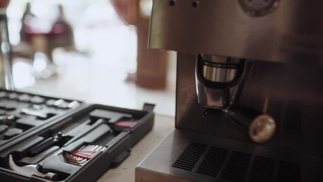 Master fixing coffee machine and shows thumb up sign. Woman uses tools for coffee maker repair. Quick fix service concept.