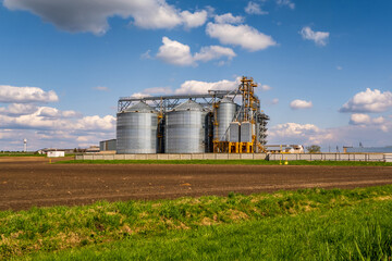 Fototapeta na wymiar panorama view on agro silos granary elevator on agro-processing manufacturing plant for processing drying cleaning and storage of agricultural products, flour, cereals and grain.