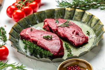 Pieces of cooked rump steak with spices served on old meat tray. Steak of marbled beef black Angus. Raw beef ramp steak, top view