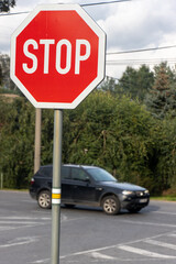 Stop sign in front of a crossing with a rides car.