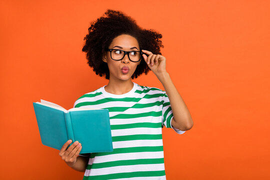 Portrait of attractive funny intellectual wavy-haired girl reading plan touch specs pout lips isolated on bright orange color background