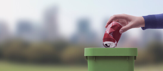 Woman putting a can in a garbage bin