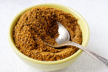 Powder spice blend from black and white mustard seeds and turmeric. Indian mustard powder seasoning in bowl.