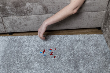 pill danger concept. the man was poisoned by pills. An arm dangled from the couch and pills were...