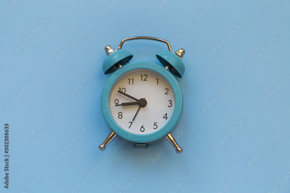 Poster alarm clock isolated on blue background with copy space