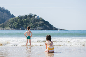 Anonymous children on wet seashore