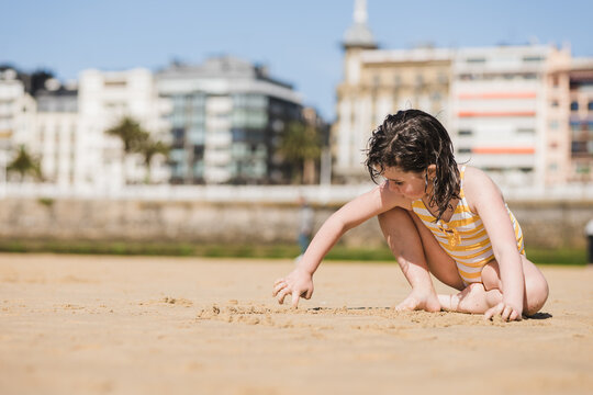 Girl playing on sandy beach