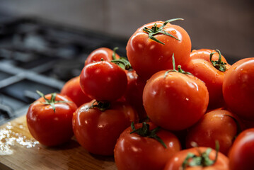 Umyte błyszczące pomidory w kuchni na desce do krojenia - obrazy, fototapety, plakaty