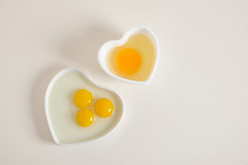 quail eggs nad chiken egg in heart shaped bowls on texture backgrund