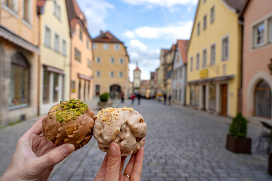 eating traditional schneeball snowball cake together the cake of the romantic Rothenburg ob der Tauber with timbered Fachwerkhaus syle houses in Bavaria Germany
