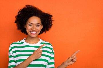 Portrait of attractive cheerful wavy-haired girl showing copy empty blank space place ad isolated...