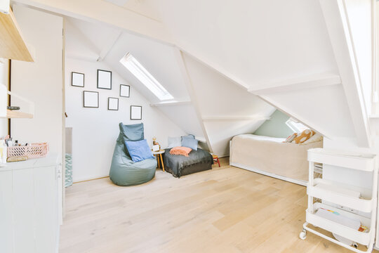 Bed on mansard with pouffe