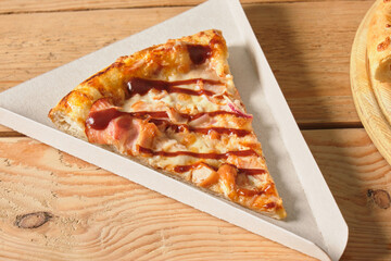 close-up of a slice of pizza in a cardboard box for serving a dish or for delivery, packaging for take away