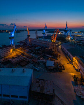 Aerial view of industrial cranes coloured with Ukrainian colours flags in memory of Russian invasion in Ukraine, Pula, Croatia.