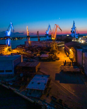 Aerial view of industrial cranes coloured with Ukrainian colours flags in memory of Russian invasion in Ukraine, Pula, Croatia.