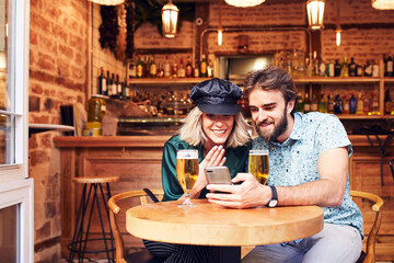 Caucasian couple having a drink at a bar.