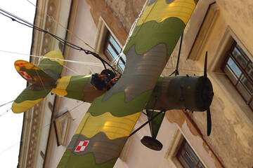 Low angle closeup of a vintage military plane hanging in the air on the streets in Lublin Poland