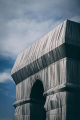 Vertical shot of the Arc de Triomphe in Paris, France wrapped in recyclable polypropylene fabric