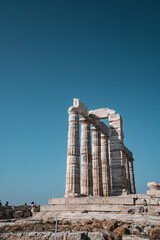 Vertical shot of columns of the Temple of Poseidon Laurium in Greece under the clear skies