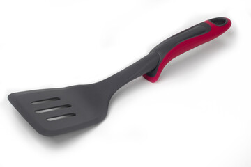 Closeup of a black plastic kitchen scraper with a red holder on a white background