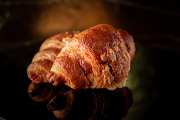 Delicious organic fresh homemade croissant on a dark background.