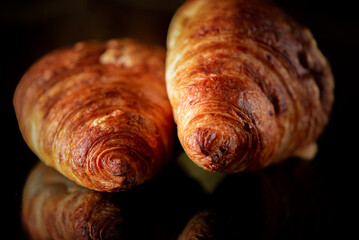 Delicious organic fresh homemade croissant on a dark background.