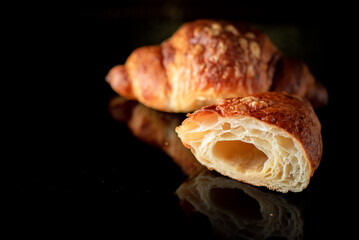 Delicious organic fresh homemade croissant on a dark background.