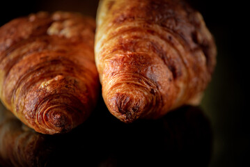 Delicious organic fresh homemade croissant on a dark background.