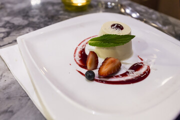 Closeup of a delicious panna cotta dessert with strawberries on a plate