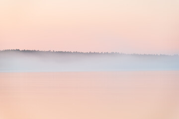 Morning light at still and misty lake