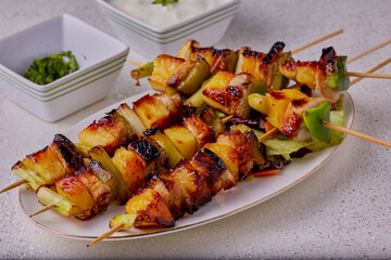 Pork and pineapple kebabs with herbs and yogurt dip.