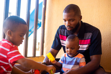 family, fatherhood and people concept - happy father and little baby daughter playing with wooden...