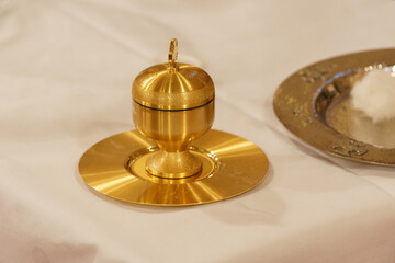 Fototapeta na wymiar Golden Brass cup with oil inside for the ceremonial sacrament of baptism