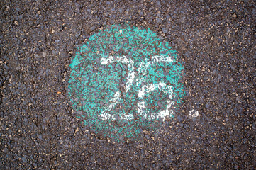 Top view of white spray paint number 26 on the asphalt ground