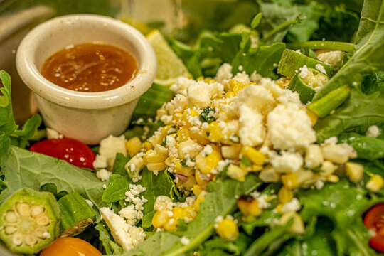 Closeup Of A Delicious Fresh Veggie Salad In A Metal Container With A Bowl Of Sauce