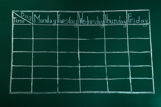 Weekly school timetable drawn on green chalkboard