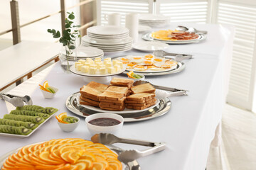Different meals for breakfast on white table indoors. Buffet service