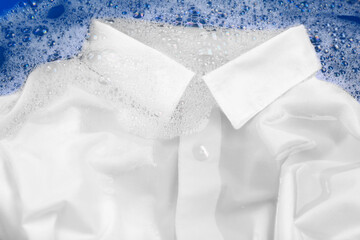 Obraz na płótnie Canvas White shirt in suds, closeup. Hand washing laundry