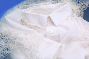 White shirt in suds, closeup. Hand washing laundry