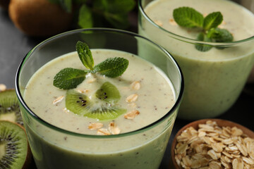 Glasses of tasty kiwi smoothie with oatmeal on table, closeup