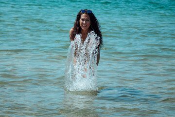young woman in bikini having fun on the shore of the beach