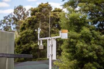 Closeup of a weather barometer, i.e. a rain gauge outdoors surrounded by lush greenery