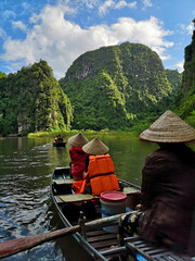Vertical shot of the tourists traveling in boats in Ninh Binh, Viet © Ken Chow/Wirestock Creators
