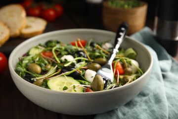 Fresh salad with vegetables, capers and mozzarella in bowl, closeup